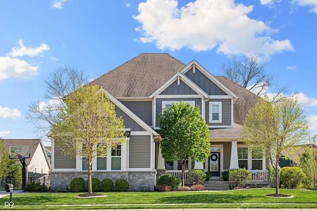 craftsman inspired home with board and batten siding, a front yard, and a porch