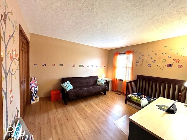 bedroom featuring light wood-style floors and a textured ceiling