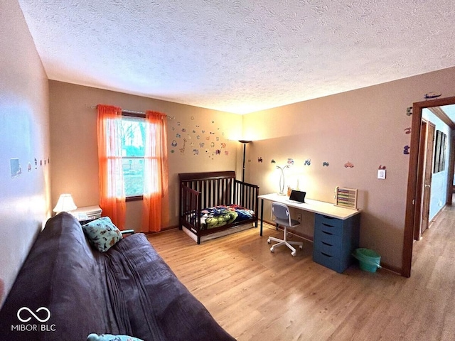 bedroom featuring a textured ceiling and light wood-style flooring