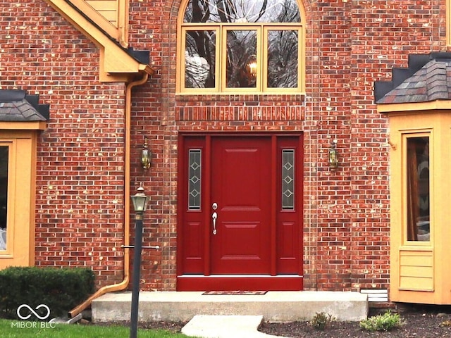 doorway to property featuring brick siding