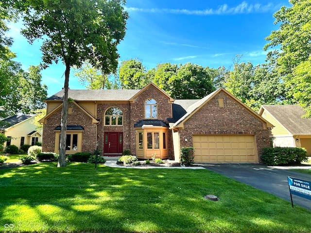 7621 Forest Dr, Fishers, IN 46038 - traditional-style home featuring brick siding, an attached garage, a front lawn, asphalt driveway, and a shingled roof