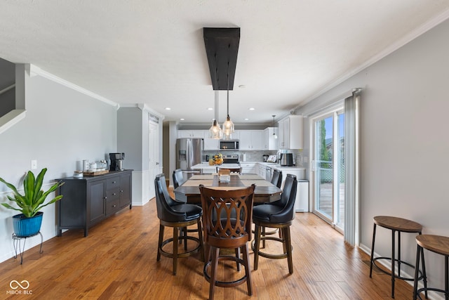 dining room with recessed lighting, baseboards, ornamental molding, and light wood-style flooring