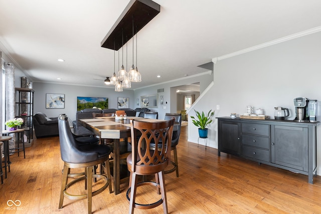 dining area with light wood-style floors, recessed lighting, and crown molding