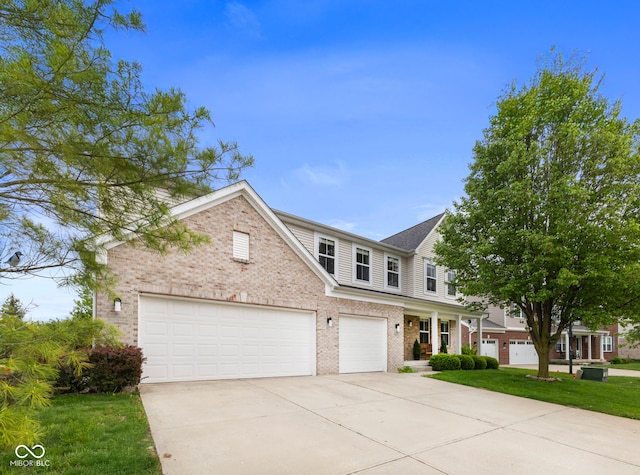 traditional home with concrete driveway, brick siding, and a front lawn