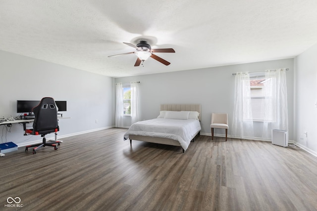 bedroom with baseboards, a ceiling fan, a textured ceiling, and wood finished floors