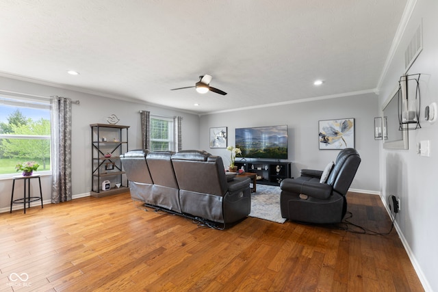 living room featuring baseboards, ceiling fan, ornamental molding, and light wood finished floors