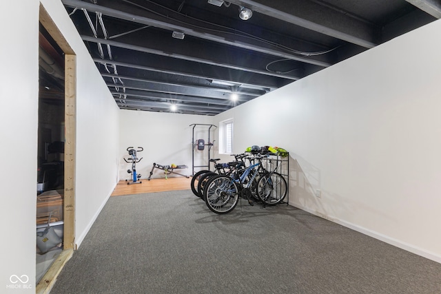 workout room featuring baseboards and carpet