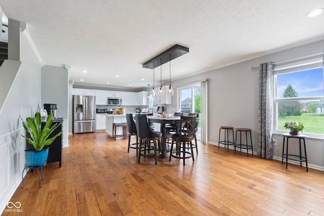 dining area featuring recessed lighting, baseboards, ornamental molding, and light wood finished floors