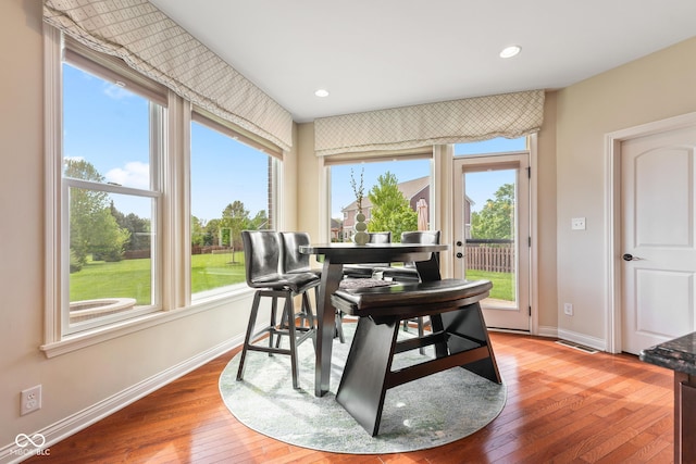 dining area featuring baseboards, light wood-style flooring, plenty of natural light, and visible vents