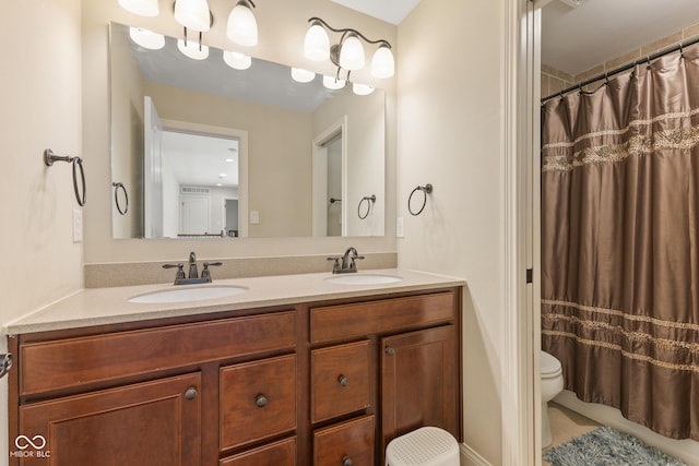 full bath with a sink, a shower with curtain, toilet, and double vanity
