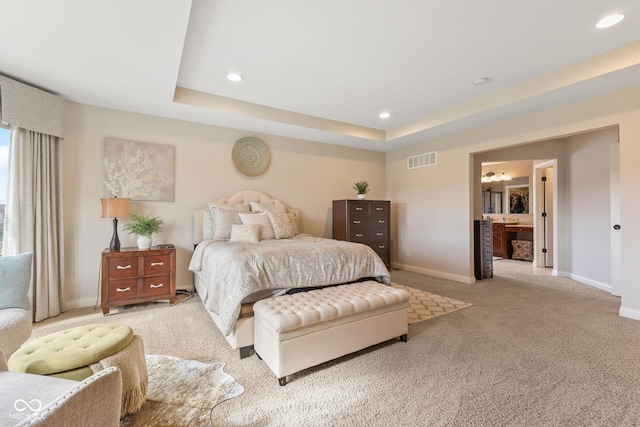 bedroom with visible vents, baseboards, light carpet, a tray ceiling, and recessed lighting