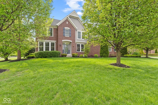 view of front of house featuring a front yard and brick siding