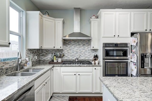 14584 Hinton Dr, Fishers, IN 46037 - kitchen with wall chimney exhaust hood, appliances with stainless steel finishes, white cabinets, a sink, and decorative backsplash