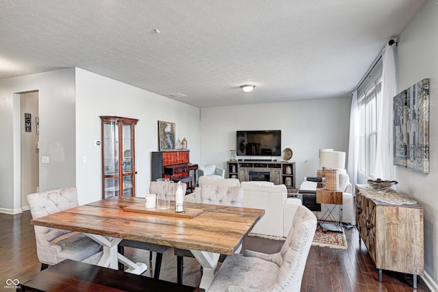 14584 Hinton Dr, Fishers, IN 46037 - dining space with dark wood-type flooring, a glass covered fireplace, baseboards, and a textured ceiling