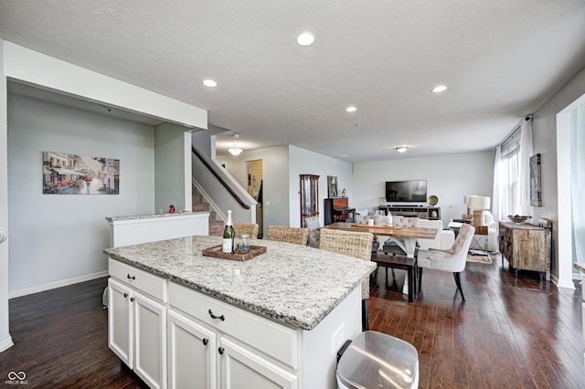 14584 Hinton Dr, Fishers, IN 46037 - kitchen with a center island, dark wood-type flooring, baseboards, light stone countertops, and recessed lighting
