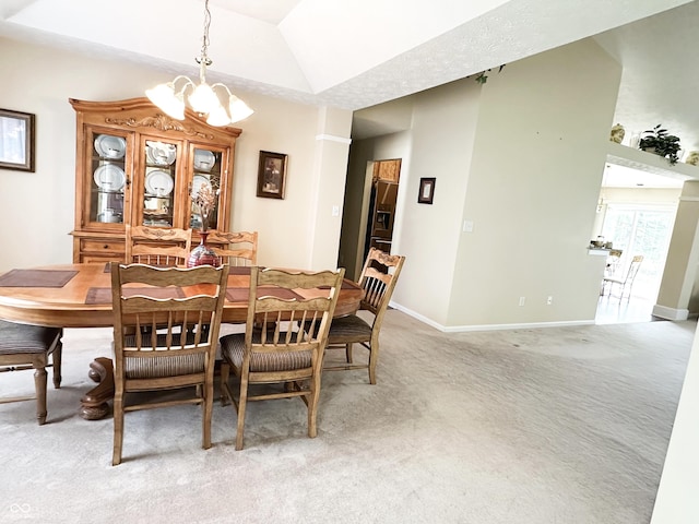 dining room with baseboards, light carpet, vaulted ceiling, and a notable chandelier