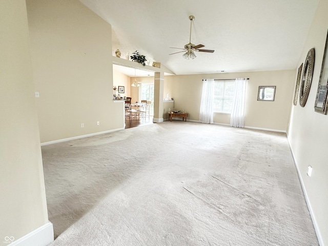 unfurnished living room featuring baseboards, a ceiling fan, high vaulted ceiling, and light colored carpet