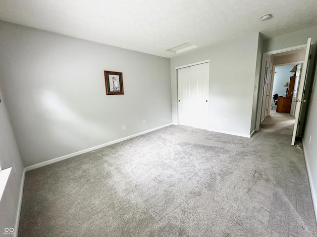 unfurnished bedroom with baseboards, carpet flooring, and a closet