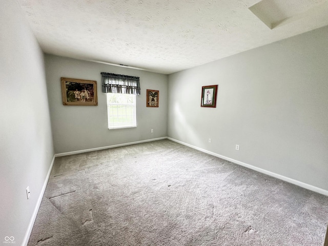 carpeted spare room with baseboards and a textured ceiling