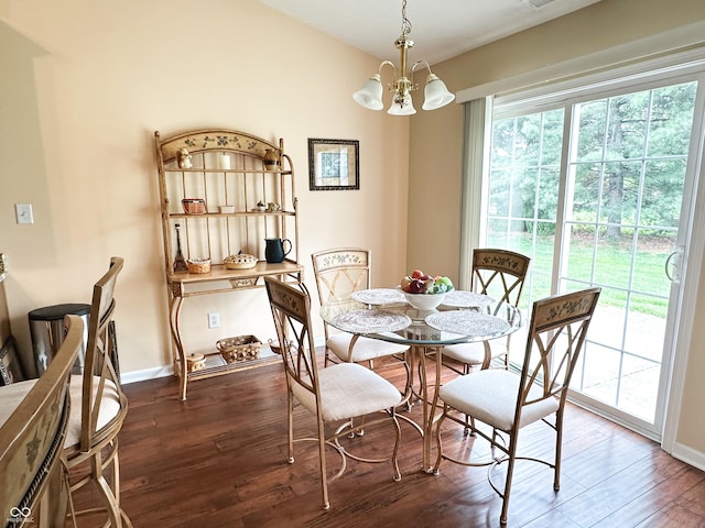 dining area featuring baseboards, wood finished floors, and a notable chandelier