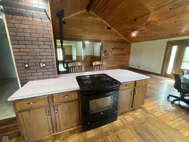 kitchen with electric range, baseboards, ceiling fan, wooden walls, and vaulted ceiling with beams