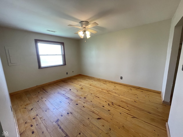 unfurnished room featuring baseboards, ceiling fan, light wood finished floors, and visible vents