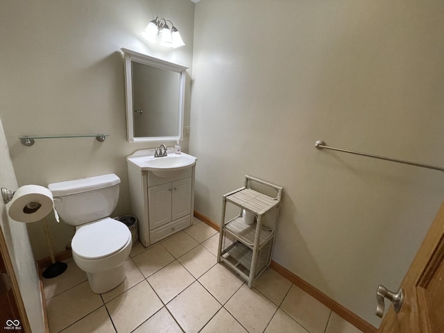 bathroom with toilet, baseboards, tile patterned flooring, and vanity