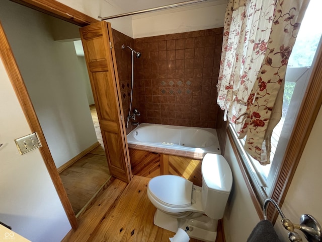 full bathroom with wood-type flooring, toilet, and shower / tub combination