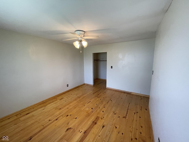 empty room with a ceiling fan, baseboards, and light wood-style floors