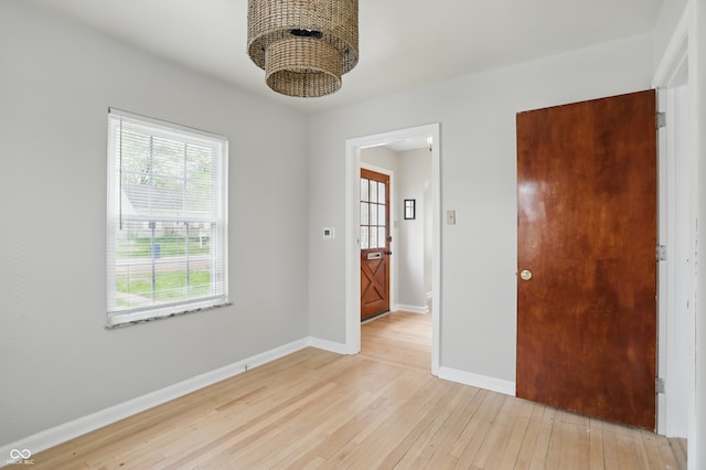 4730 Rookwood Ave, Indianapolis, IN 46208 - unfurnished room featuring baseboards, a chandelier, and light wood-type flooring
