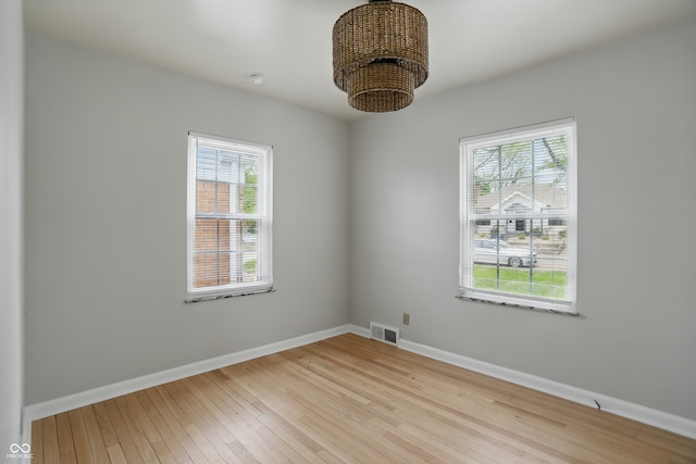 4730 Rookwood Ave, Indianapolis, IN 46208 - empty room with visible vents, light wood-style floors, baseboards, and a healthy amount of sunlight