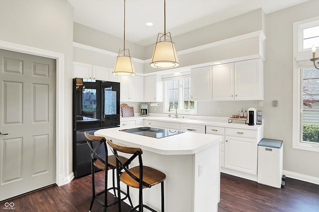 kitchen with a sink, plenty of natural light, black appliances, and dark wood-style floors