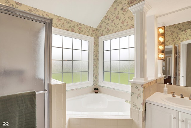bathroom with vaulted ceiling, vanity, a garden tub, and wallpapered walls