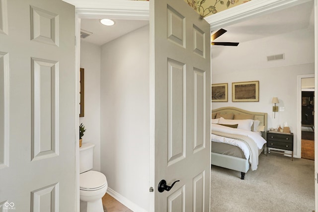bathroom featuring toilet, ceiling fan, visible vents, and baseboards