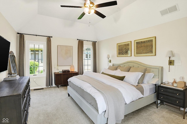 bedroom featuring visible vents, a ceiling fan, vaulted ceiling, and light carpet
