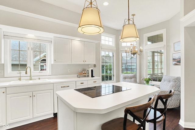 kitchen featuring a sink, a center island, dark wood-style floors, and black electric stovetop