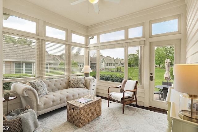 sunroom / solarium with a ceiling fan, wood finished floors, and an outdoor hangout area