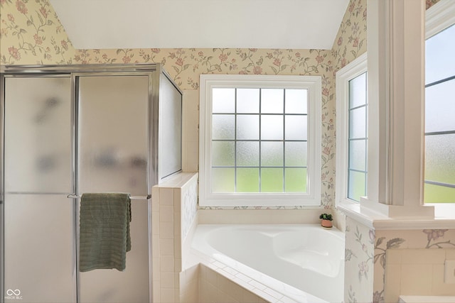 full bath with a healthy amount of sunlight, a stall shower, wallpapered walls, and a garden tub