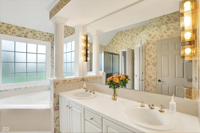 full bath with wallpapered walls, decorative columns, and a sink