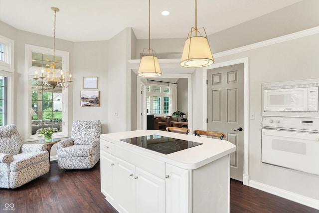 kitchen with a kitchen island, white appliances, white cabinetry, a chandelier, and dark wood finished floors