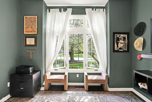 living area featuring baseboards and visible vents