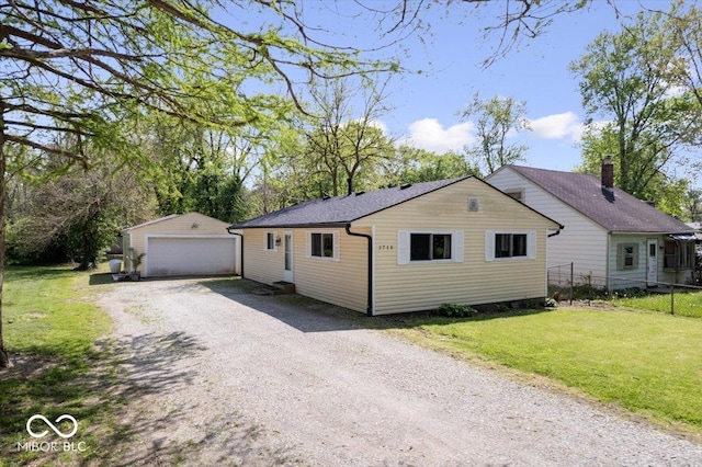 view of side of home featuring a lawn, fence, an outbuilding, and a garage