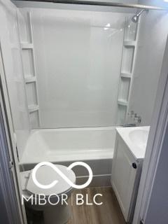 1710 S Birch St, Muncie, IN 47302 - full bath featuring vanity, bathtub / shower combination, and wood finished floors