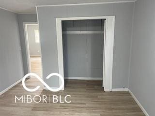 1710 S Birch St, Muncie, IN 47302 - unfurnished bedroom featuring wood finished floors, baseboards, and ornamental molding