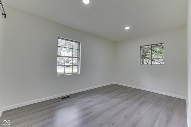 unfurnished room with recessed lighting, baseboards, visible vents, and wood finished floors