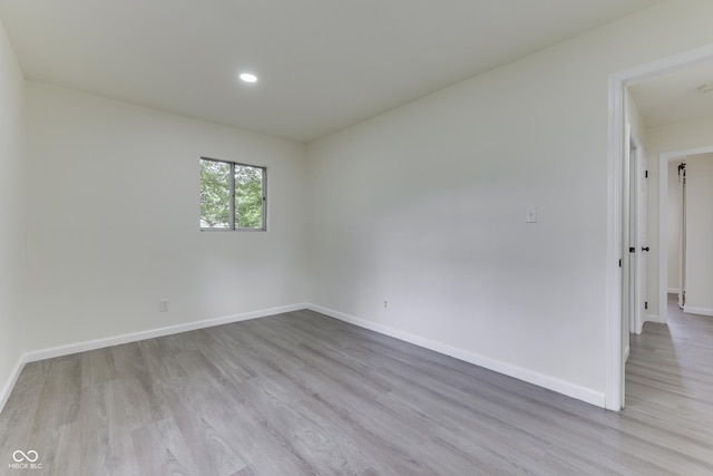 unfurnished room featuring baseboards, recessed lighting, and wood finished floors