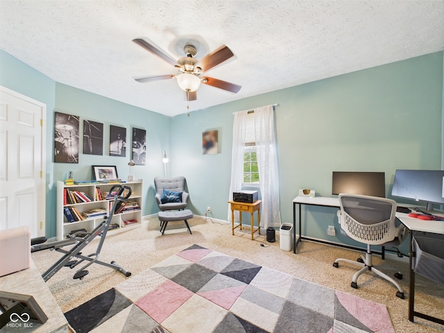 carpeted home office with baseboards, a ceiling fan, and a textured ceiling