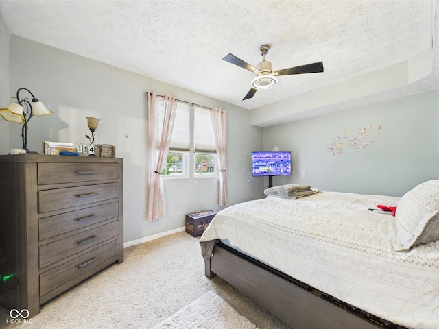 bedroom with baseboards, a ceiling fan, a textured ceiling, and light colored carpet