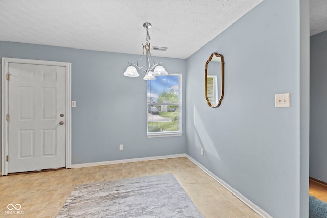 unfurnished dining area featuring baseboards, a chandelier, visible vents, and a textured ceiling