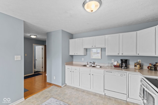 kitchen featuring baseboards, white appliances, a sink, white cabinetry, and light countertops